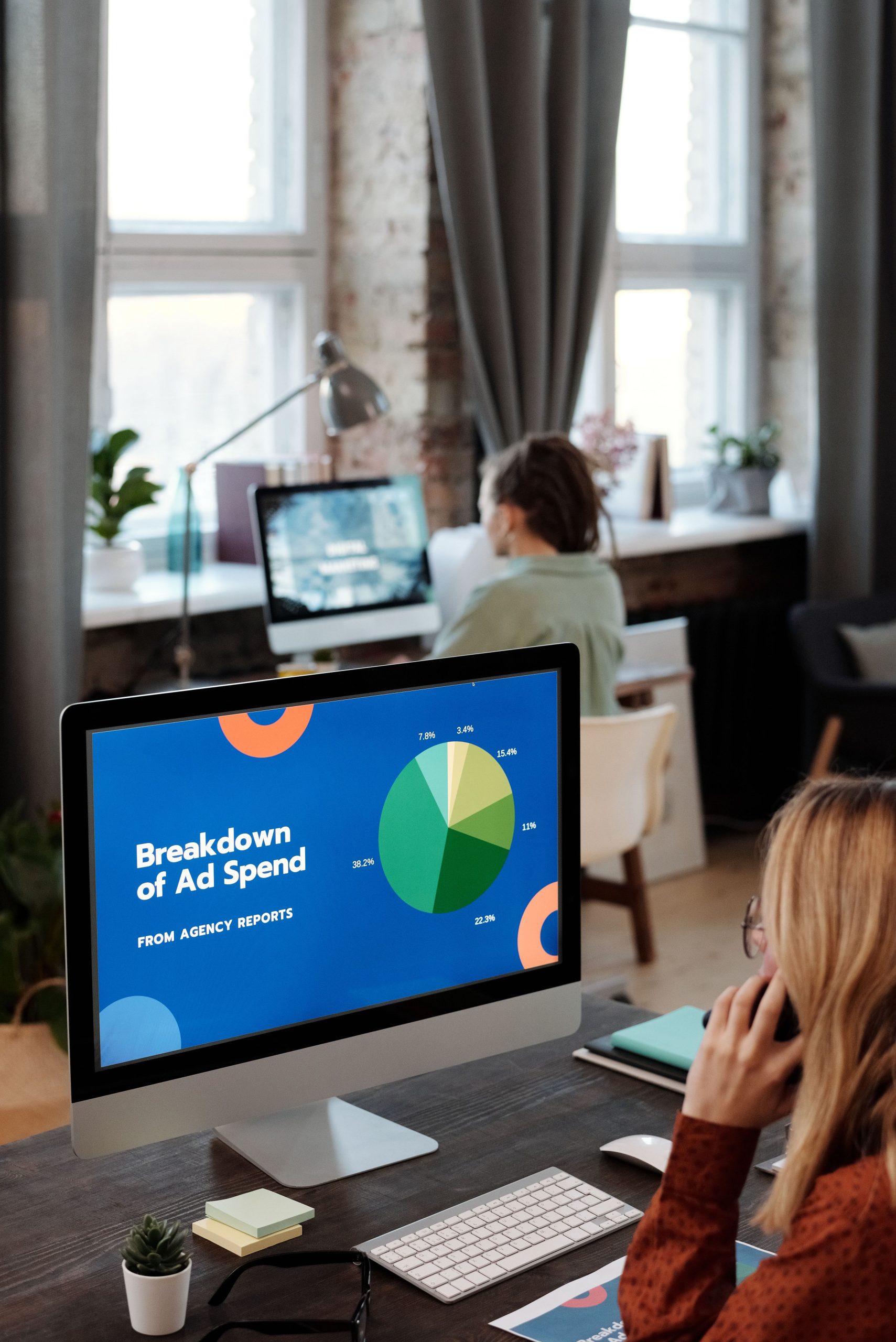 Bright office setting with computers displaying data, illustrating productivity in a workspace.