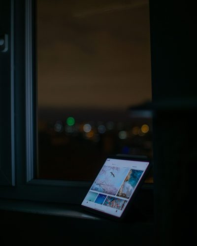 Digital tablet by a window overlooking a blurred night cityscape, creating a tranquil ambiance.